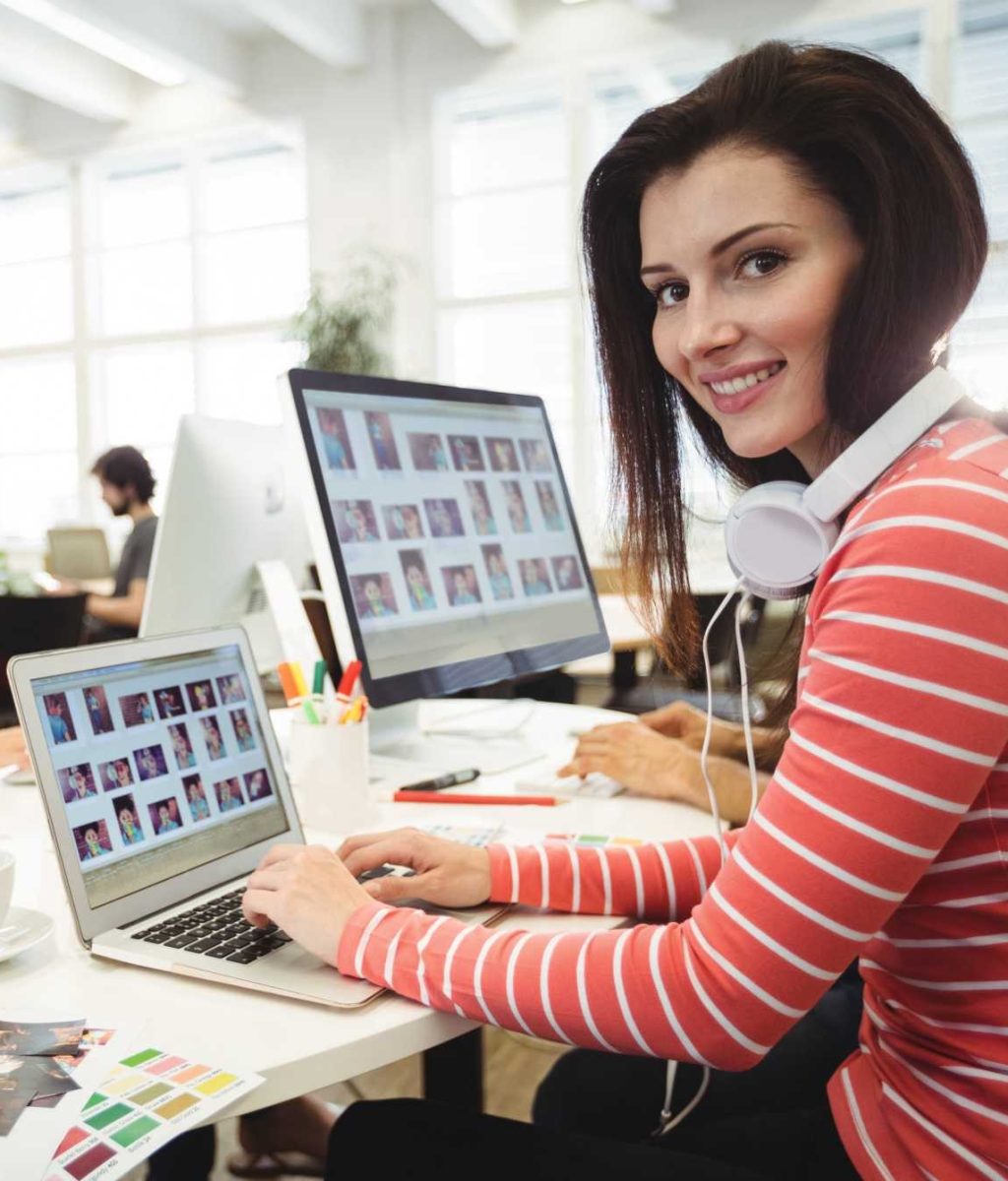 graphic-designer-looking-camera-while-colleague-working-ba (1)